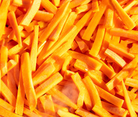 Fresh orange carrots sliced as a background.