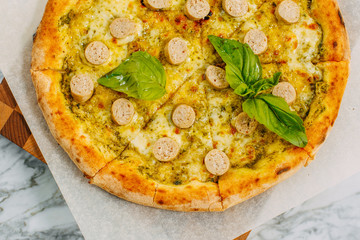 Italian pizza with mozzarella cheese and basil on a marble table