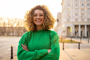 Portrait of young woman with curly hair in the city

