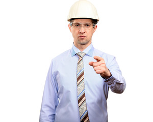 A confident man is engineered in a construction helmet, glasses, shirt and tie shows a finger into the camera. Isolated