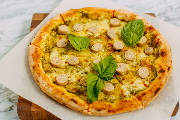 Italian pizza with mozzarella cheese and basil on a marble table