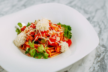 Italian spaghetti with cheese and herbs on a marble table