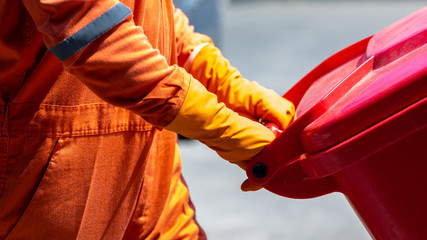 Man in protective suit and disposal container for Infectious waste, Infectious waste must be...