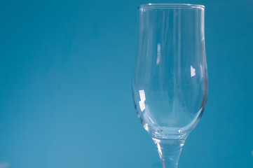 Empty glass on a blue background.Tableware for alcohol.A glass for champagne and wine.