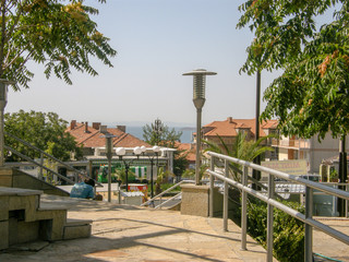 Top view of densely built low houses with tiled roofs descending to the sea