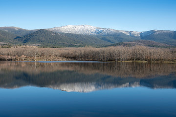 Fototapeta na wymiar Ponton Reservoir in Segovia; Castilla y Leon, Spain; Europe. Nice reflection in the water of the landscape surrounding the reservoir.