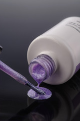 violet nail polish with shimmer on grey background