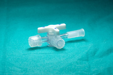 Three way stopcock with luer slip For medical purposes On a green cloth