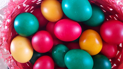 eggs colored for easter red green and yellow in a basket