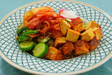 Grain bowl with cubed tofu, Korean kimchi, and fresh vegetable