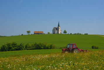 Slovenian countryside in spring with charming little church on a hill, in Slovenia