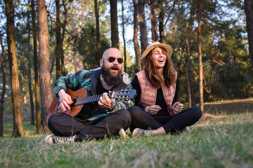 Couple singing and playing guitar outdoors
