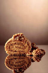 Walnut cake on a reflective background.