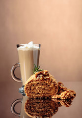 Walnut cake and coffee latte with cream on a reflective background.
