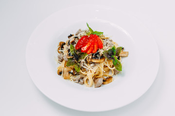 Italian pasta in a creamy sauce with mushrooms champignon on a white plate
