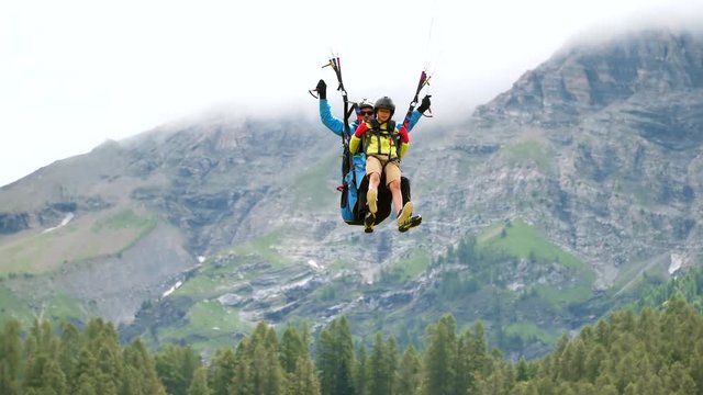 Boy study paragliding with instructor, flying with parachute high.