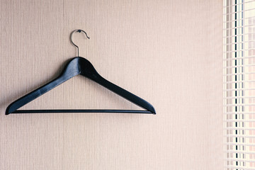 A clothes hanger hangs on a nail driven into the wall. Next to the window opening, the window has...