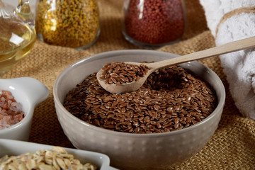 a bowl full of linseed in the company of other seeds for the production of homemade body cosmetics