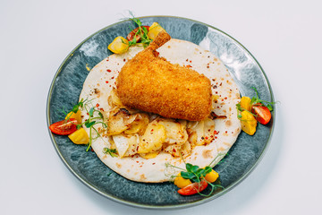 breaded chicken leg with fried potato wedges and pita bread on an isolated white background