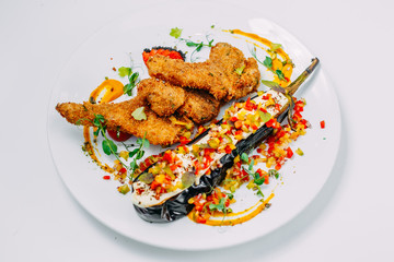 breaded chicken with stuffed eggplant and pepper on an isolated white background