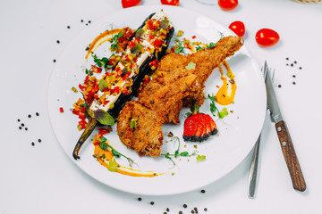 breaded chicken with stuffed eggplant and pepper on an isolated white background