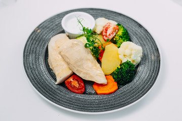 boiled chicken breast with broccoli and vegetables, healthy nutrition, on a white background
