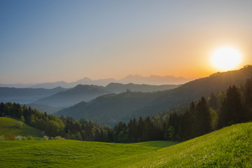 Obraz premium Slovenian breathtaking landscape at sunrise and Julian Alps in the background, in spring. Beautiful misty morning in the mountains in Slovenia.