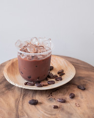 Ice chocolate drink with foam and cacao beans  isolated on white background.