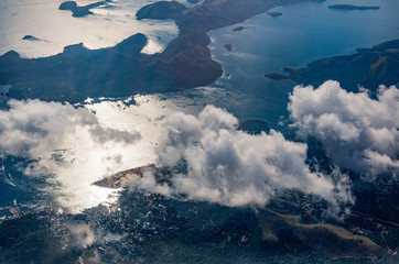 Fototapeta premium Coron Island seen from a plane window above the clouds in Philippines