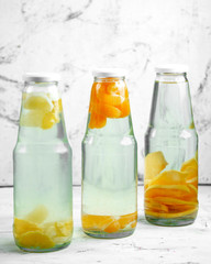 refreshments with tangerine, grapefruit, and quince in bottles