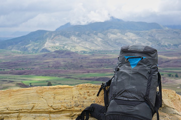 Close-up of a black backpacker's backpack against the backdrop of the Maragua volcanic crater in...