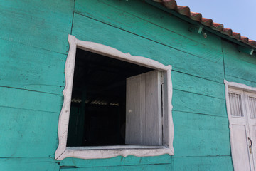 window open for visiting with neighbors on a turquoise painted home in a Mexican fishing village

