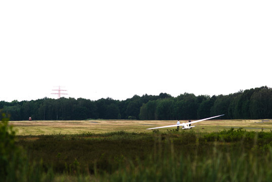 Segelflugzeug vor dem Start an einer Seilwinde vor B&auml;umen und Strommast 