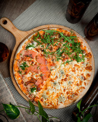 salmon pizza with vegetables on the table