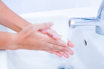 Close-up of young women washing hands with soap rubbing fingers and skin under faucet water flows on white basin for pandemic prevention Corona virus, Covid-19