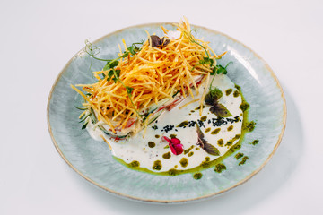 salad with french fries and sauce on a decorated white table