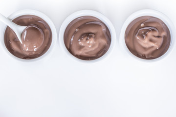 chocolate pudding in bowls top view. background with chocolate pudding in white bowls close-up. chocolate pudding and a copy of space.