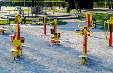 An empty sport playground, whose exercisers wrapped with a warning red and white tape. Forbidden to visit during the quarantine period of the pandemic of COVID-19 disease caused by coronavirus