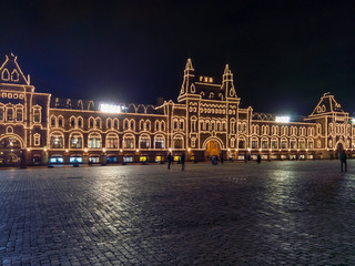 Evening view of the GUM with illumination from the side of an empty red square as a symbol of quarantine