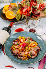 baked chicken with potatoes garnished on a white plate with wine