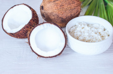 halves of a coconut, a whole coconut and a bowl of coconut paste close-up. background with fresh coconuts and coconut paste.