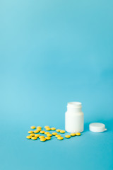 Scattered white pills on blue table. Mock up for special offers as advertising, web background or other ideas. Medical, pharmacy and healthcare concept. Copy space. Empty place for text or logo.