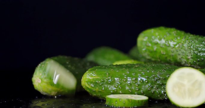 Round slices of cucumber falling on the table.