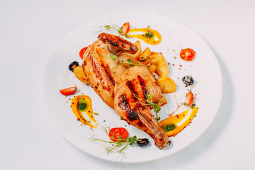 grilled chicken with potatoes on a decorated white table