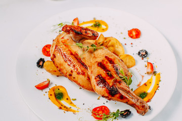 grilled chicken with potatoes on a decorated white table