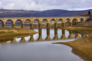 Fototapeta na wymiar lake crossed by a bridge and its reflection