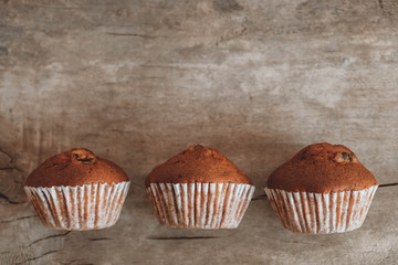 Chocolate cupcakes on wooden table background. Top view. Copy, empty space for text