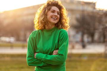 Portrait of young woman with curly hair in the city
