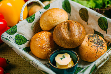 fresh buns with butter in a basket, healthy food on a decorated table