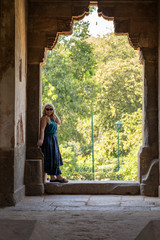 Blonde woman stands in an arched doorway while exploring tombs of Lodi Garden in New Delhi India